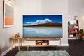 Image of a Samsung TV with a beach and mountain on the display in a living room.
